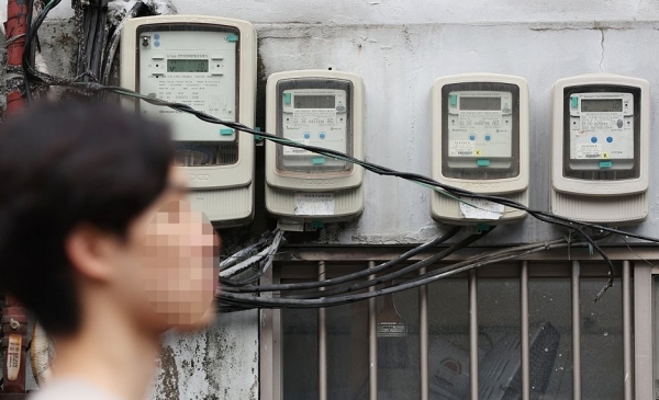 올해 3분기 전기요금의 연료비 조정단가 발표가 예정된 27일 오후 서울 시내의 전기계량기 앞을 한 시민이 지나가고 있다 (사진=연합뉴스)