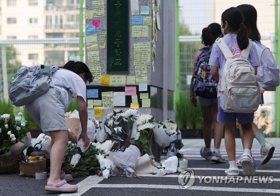 20일 오전 서초구 한 초등학교 앞에 등굣길 학생이 헌화를 하고 있다.(연합뉴스) 