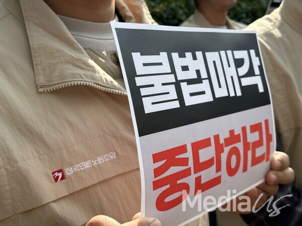 ​23일 그랜드하얏트 서울 호텔에서 열린 'YTN 불법 매각 중단 촉구' 기자회견에서 전국언론노동조합원이 '불법매각 중단하라' 피켓을 들고 있다.(사진=미디어스)​