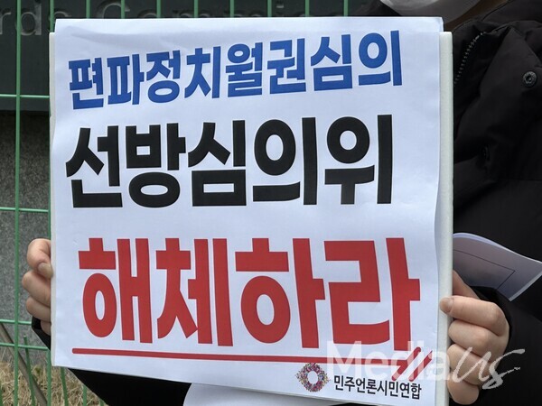 28일 서울 목동 코바코 방송회관 앞에서 열린 '선방심의위 해체 촉구' 기자회견에서 한 참석자가 피켓을 들고 있다.(사진=미디어스)