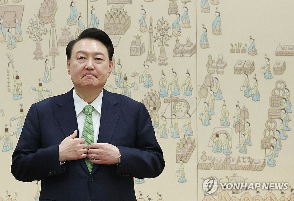 윤석열 대통령이 26일 서울 용산 대통령실 청사에서 열린 주한대사 신임장 제정식 중 옷매무새를 가다듬고 있다.(연합뉴스)