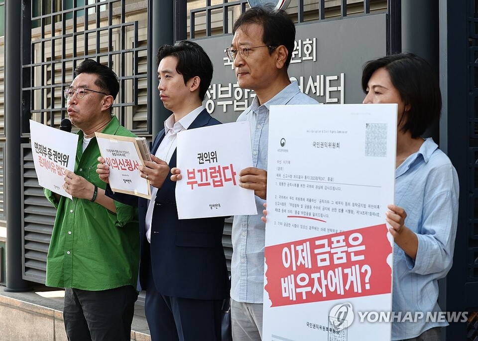 19일 서울 종로구 국민권익위원회 정부합동민원센터 앞에서 열린 국민권익위의 대통령 부부 명품 수수 신고사건 종결 처리에 대한 이의신청 및 기자회견에서 참여연대 관계자들이 손팻말을 들고 있다. (서울=연합뉴스)