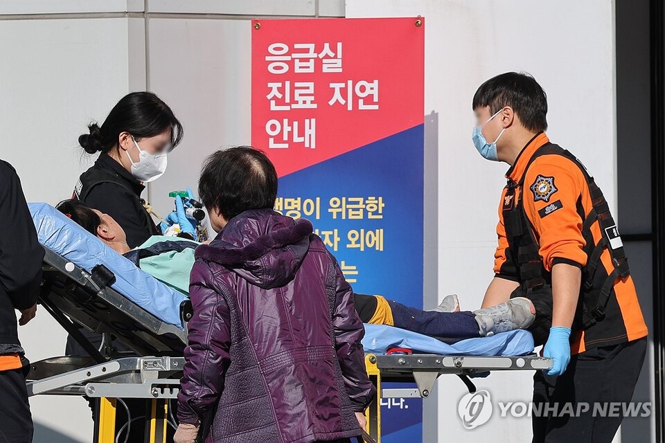 8일 서울 시내의 한 대학병원 응급의료센터로 이송되는 환자 뒤에 응급실 지연 안내문이 놓여 있다. (서울=연합뉴스)