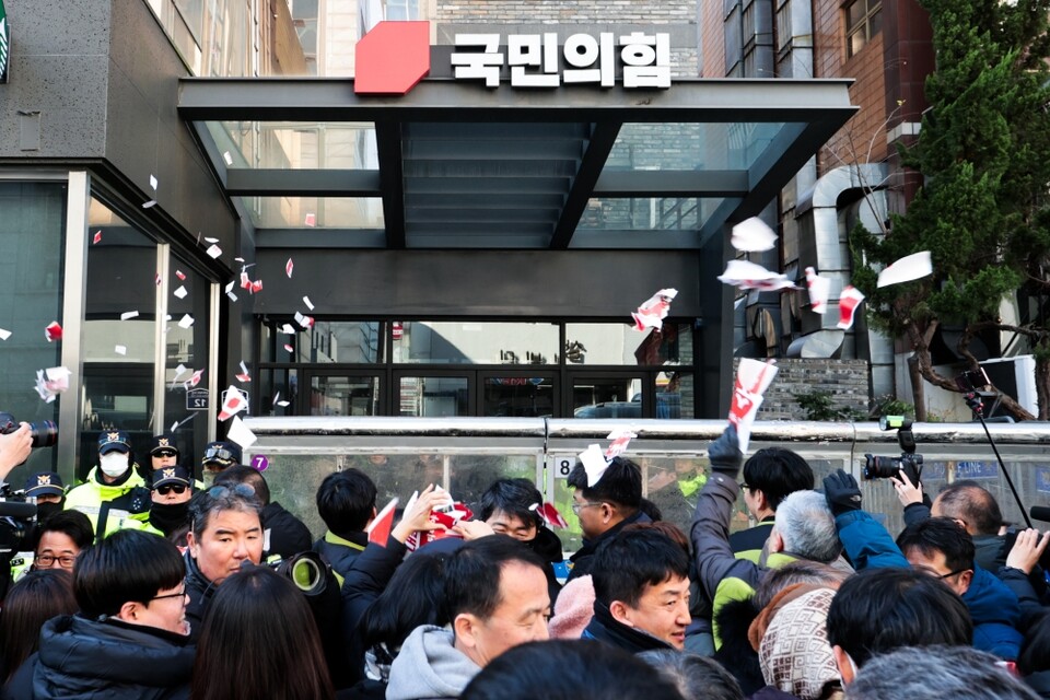 민주노총 조합원들이 9일 오전 서울 여의도 국민의힘 당사 앞에서 열린 국민의힘 해체 요구 기자회견에서 국민의힘 의원들의 이름이 쓰인 종이를 찢은 뒤 당사에 던지고 있다 (사진=연합뉴스)