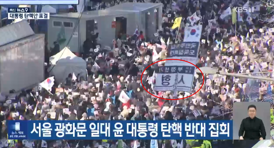 KBS '뉴스9' 12월 7일 서울 광화문 일대 윤 대통령 탄핵 반대 집회 보도화면. '부정선거 사형'이라는 문구가 적힌 깃발이 휘날리는 모습이 보도되고 있다.