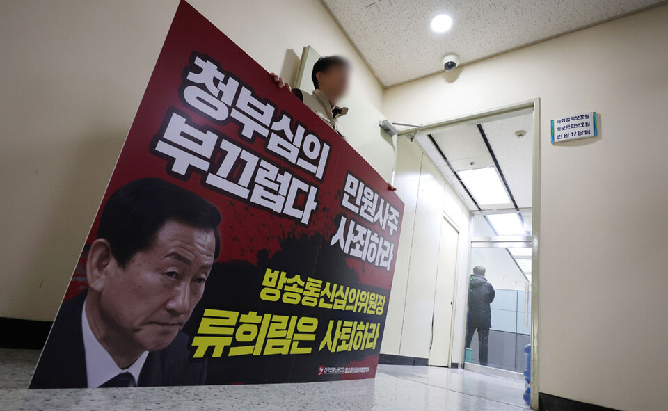 1월 15일 방송통신심의위원회 내부 직원이 민원인의 개인정보를 유출했다는 의혹과 관련해 경찰 수사관들이 서울시 목동 한국방송회관에 있는 방송통신심의위윈회 민원상담팀 등을 압수수색 하는 중에 노조측 관계자가 류희림 위원장의 사퇴를 촉구하는 팻말을 들고 있다. (서울=연합뉴스)