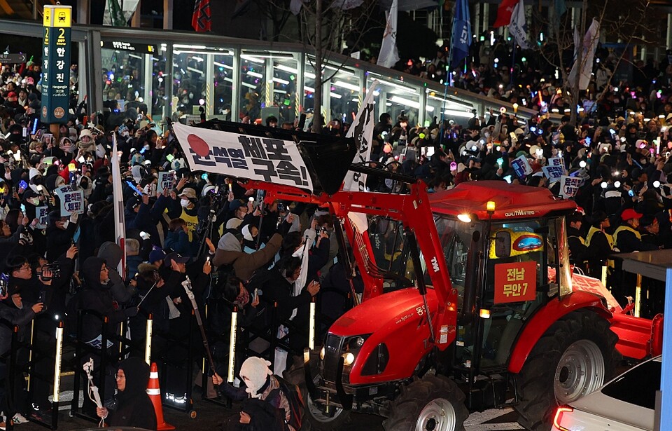 지난 22일 서울 용산구 한강진역에서 열린 '윤석열 대통령 체포·구속 농민 행진 보장 촉구 시민대회'에서 참가자들이 트랙터를 보며 환호하고 있다 (사진=연합뉴스)