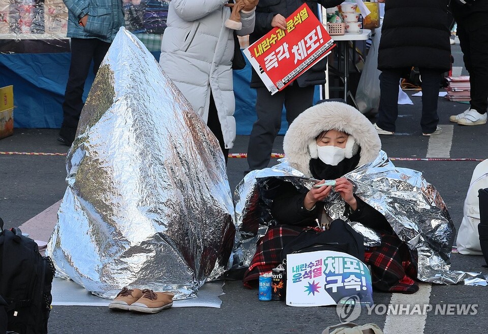 12일 서울 용산구 한남동 대통령 관저 인근에서 은박 담요를 덮은 시민들이 윤석열 탄핵 찬성 집회를 이어가고 있다.(사진=연합뉴스)