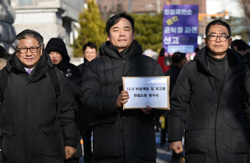 '윤석열 즉각퇴진·사회대개혁 비상행동' 소속회원들이 지난 7일 오전 서울 종로구 헌법재판소 앞에서 '12.3 비상계엄 및 포고령 헌법소원 청구 기자회견 후 청구서 접수를 위해 민원실로 이동하고 있다 (사진=연합뉴스)