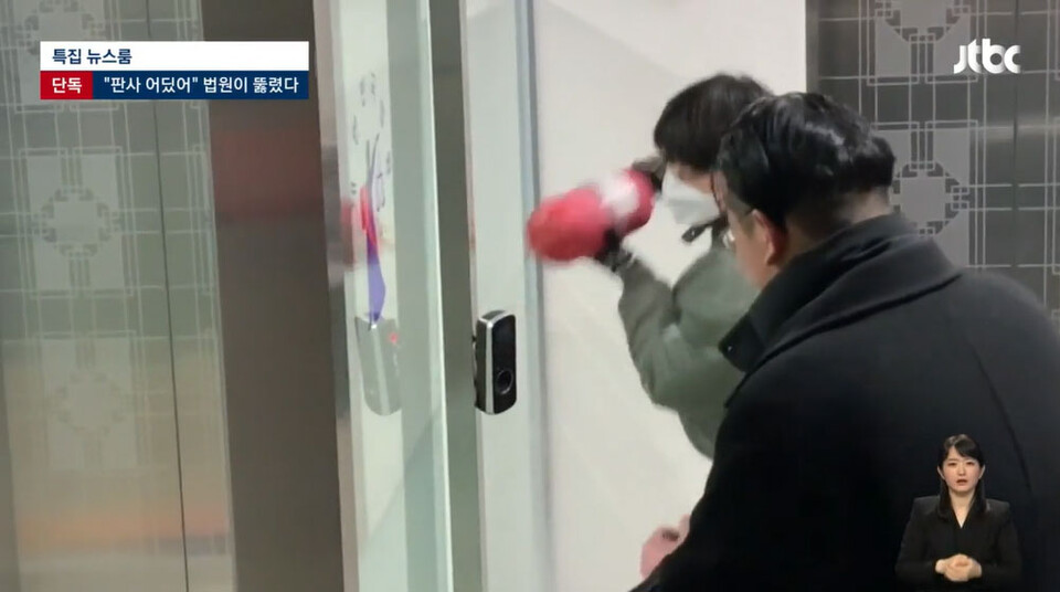 19일 새벽 서부지법에 난입한 한 폭도가 소화기를 들고 법원청사 출입문을 부수고 있다.(19일 JTBC 뉴스룸 방송화면 갈무리)