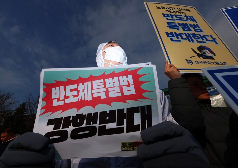 지난 10일 서울 여의도 국회 앞에서 열린 '재벌 특혜 반도체특별법 저지 및 노동시간 연장 반대 공동행동 출범 기자회견'에서 방진복을 입은 참가자가 피켓을 들고 있다. 민주노총 금속노조, 한국노총 전국금속노동조합연맹, 정의당 및 시민사회단체로 구성된 공동행동은 반도체특별법이 노동자들의 노동시간을 늘리고 기후 위기와 환경 파괴를 초래한다며 특별법 제정 중단을 촉구했다 (사진=연합뉴스)