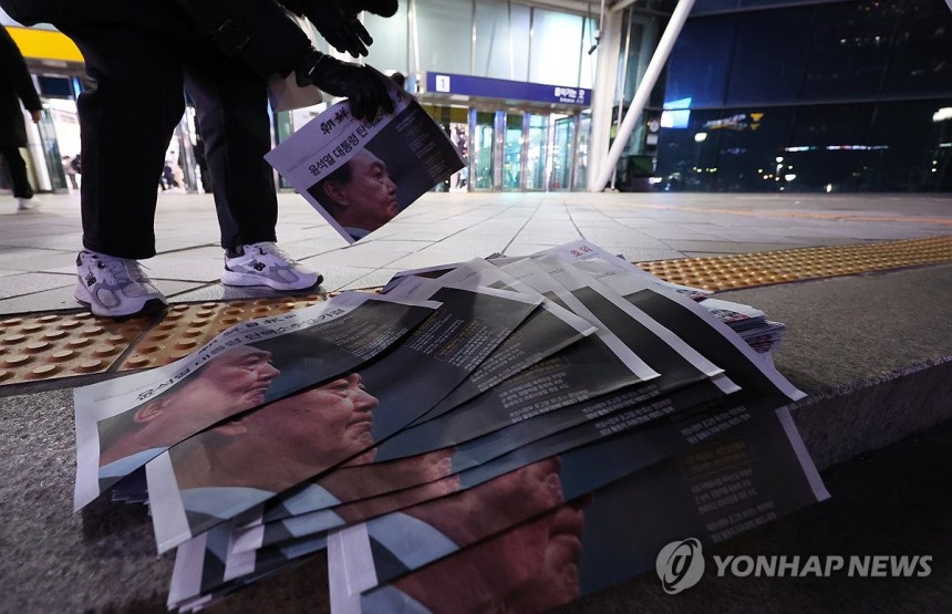 윤석열 대통령 탄핵소추안이 가결된 14일 서울역에서 시민들이 탄핵안 가결 뉴스를 실은 신문 호외를 가져가고 있다. (사진=연합뉴스)