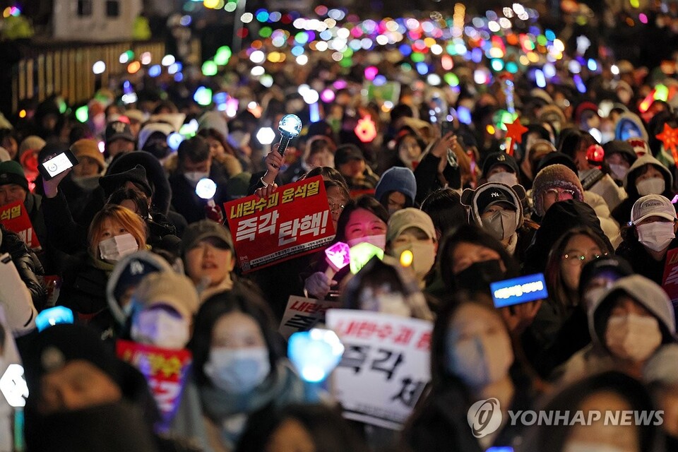 2024년 12월 8일 오후 서울 여의도 국회 앞에서 열린 윤석열 탄핵 및 구속을 촉구하는 촛불문화제에서 참가자들이 관련 손팻말과 응원봉을 들고 있다. (서울=연합뉴스)