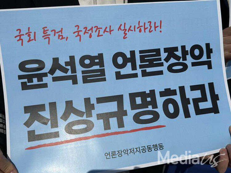 8일 서울 종로구 광화문광장에서 열린 '내란세력 척결하고 언론정상화 투쟁에 나서자' 기자회견에서 한 참석자가 피켓을 들고 있다.(사진=미디어스)