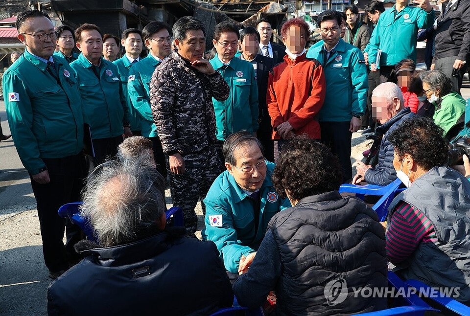 한덕수 대통령 권한대행이 2일 경북 영덕군 노물리 산불피해 현장에서 주민들을 위로하고 있다. 