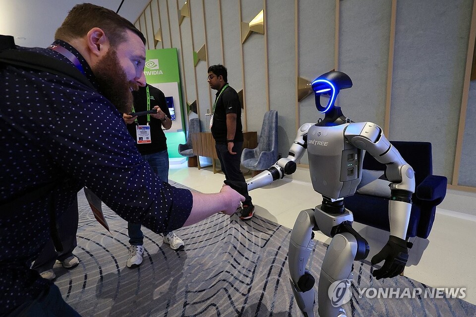 세계 최대 가전·정보기술(IT) 전시회 CES 2025 개막인 지난 1월 7일 오전(현지시간) 미국 네바다주 라스베이거스 퐁텐블루 호텔 엔비디아 전시관에서 휴머노이드 로봇 유니트리 G1이 관람객과 악수하고 있다. (라스베이거스=연합뉴스)