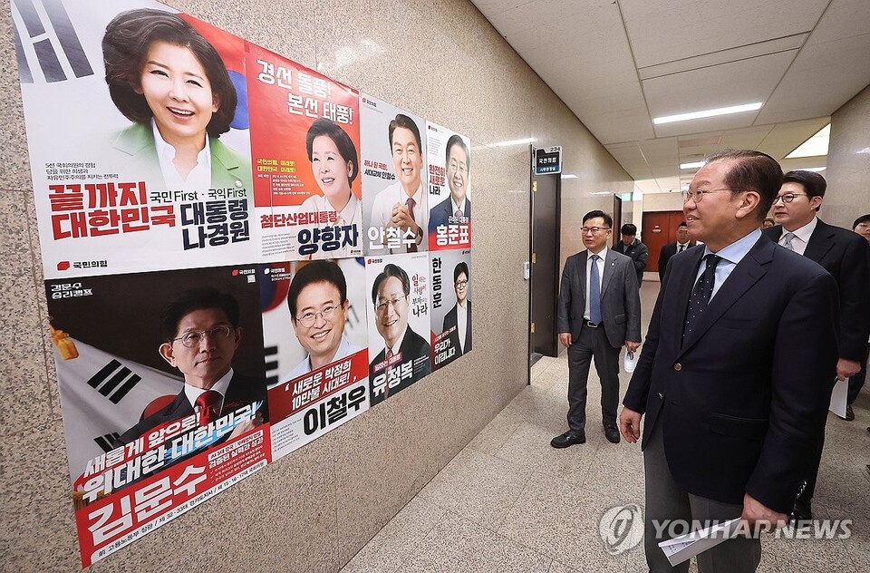 국민의힘 권영세 비상대책위원장이 21일 국회에서 열린 비상대책위원 회의에 참석하며 대선 경선 후보자들의 포스터를 살펴보고 있다. (서울=연합뉴스)