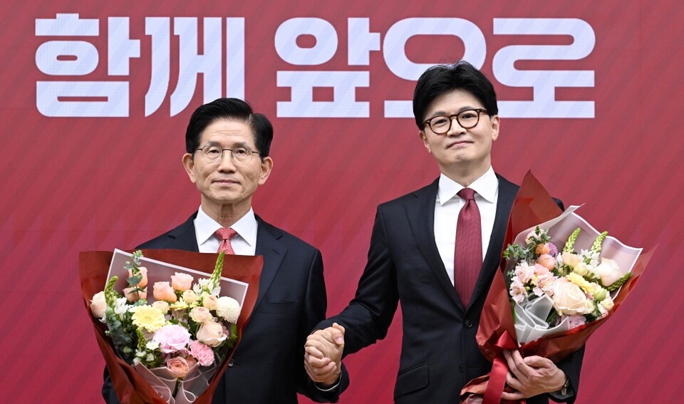 국민의힘 대선 최종 경선에 진출한 김문수(왼쪽)·한동훈 후보가 지난 29일 서울 여의도 당사에서 3차 경선 결과 발표 후 꽃다발을 들고서 기념촬영 하고 있다(사진=연합뉴스)