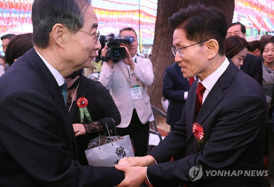 봉축법요식 마치며 인사하는 김문수 대선 후보와 한덕수 대선 예비후보 국민의힘 김문수 대선 후보(오른쪽)와 무소속 한덕수 대선 예비후보가 5일 서울 종로구 조계사에서 열린 불기 2569년 부처님오신날 봉축법요식을 마친 뒤 악수하고 있다.(연합뉴스)