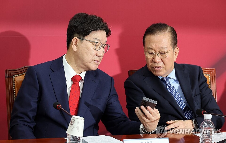 국민의힘 권영세 비상대책위원장과 권성동 원내대표가 8일 국회에서 열린 비상대책위원회의에서 휴대전화를 보며 대화하고 있다.(연합뉴스)