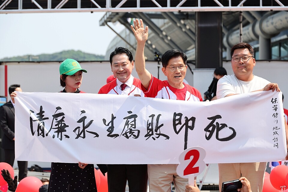 국민의힘 김문수 대선 후보가 25일 충남 보령시 대천역 광장 유세에서 '청렴영생 부패즉사'라는 글귀가 적힌 현수막을 들고 있다 (사진=연합뉴스)