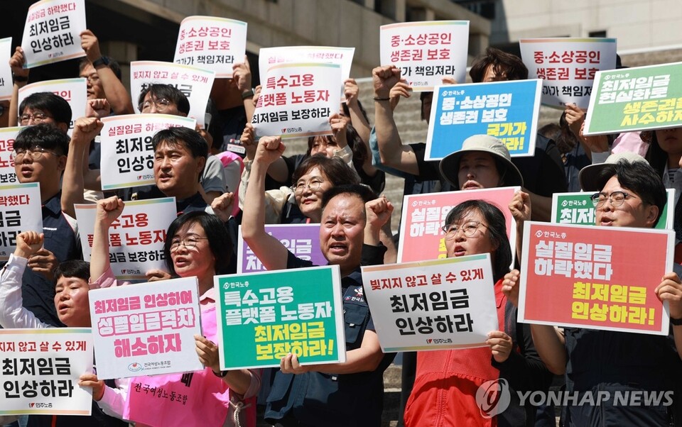 '모두를 위한 최저임금 운동본부'와 양대노총 조합원들이 11일 서울 종로구 세종문화회관 계단에서 내년에 적용할 최저임금 요구안을 발표하며 구호를 외치고 있다. (서울=연합뉴스)