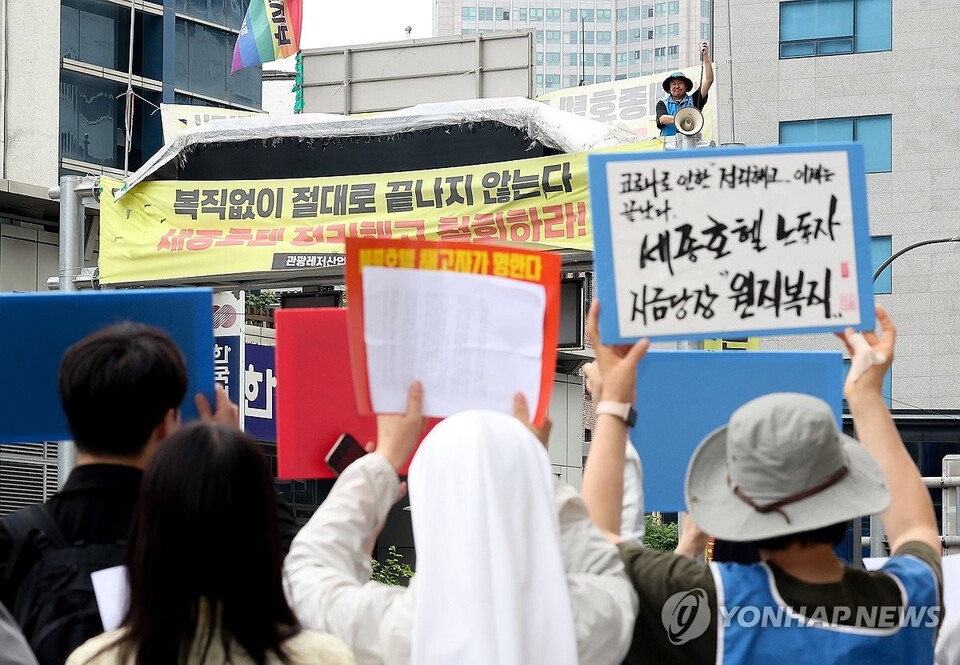 5월 20일 서울 중구 명동 세종호텔 앞에서 열린 '고진수 세종호텔 해고노동자 고공농성 100일, 사회원로·종교·시민사회단체 기자회견'에서 고진수 씨를 포함한 참가자들이 구호를 외치고 있다. (서울=연합뉴스)