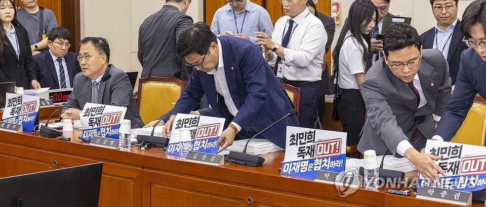 국민의힘 과학기술정보방송통신위원들이 14일 서울 여의도 국회 과방위에서 열린 배경훈 과학기술정보통신부 장관 후보자 인사청문회에 입장해 국회에서 처리됐던 방송3법에 항의하는 의미의 인쇄물을 노트북에 붙이고 있다. (서울=연합뉴스)