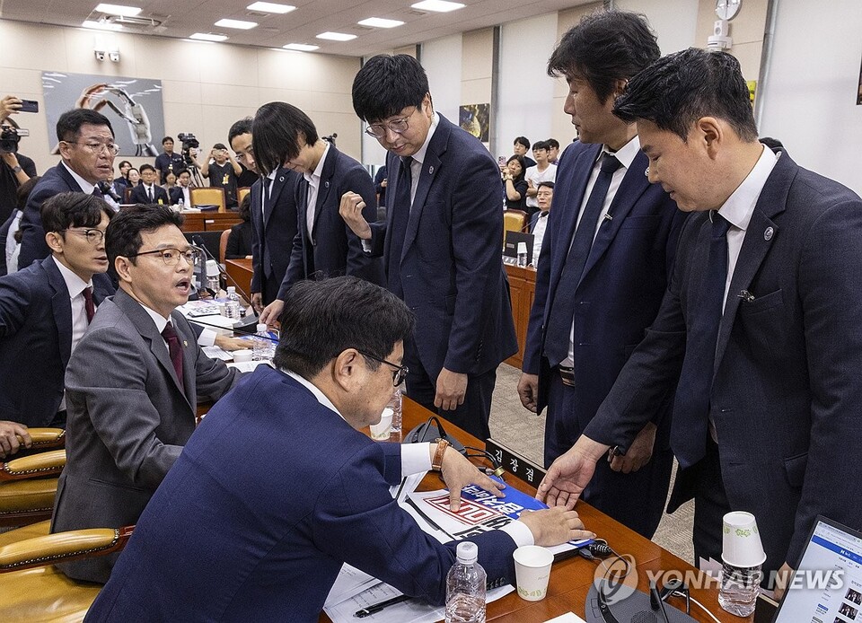 14일 서울 여의도 국회 과학기술정보방송통신위에서 열린 배경훈 과학기술정보통신부 장관 후보자 인사청문회에서 국회 경위들이 최민희 위원장의 요청에 따라 국민의힘 과방위원들이 노트북 앞에 붙인 인쇄물을 제거하기 위해 야당 의원석 앞에 서 있다. (서울=연합뉴스)