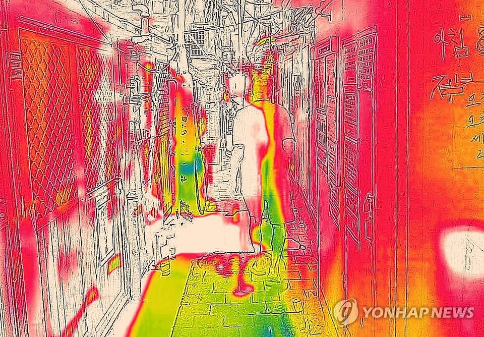 폭염이 이어지고 있는 9일 서울 종로구 쪽방촌에서 더위를 피하고 있는 한 주민을 열화상 카메라로 촬영한 모습. 온도가 높은 곳은 붉게, 낮은 곳은 푸르게 표시돼 있다. (서울=연합뉴스)