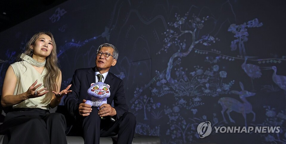 8월 21일 서울 용산구 국립중앙박물관은 예방한 넷플릭스 애니메이션 '케이팝 데몬 헌터스'의 매기 강 감독(왼쪽)이 유홍준 관장과 함께 디지털 실감영상관에서 영상을 감상하고 있다. 서울=연합뉴스)