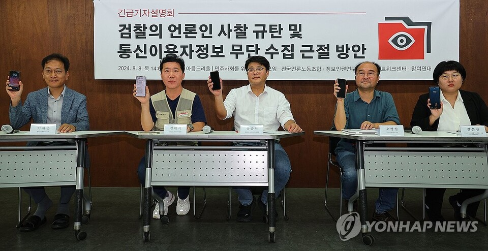 전대식 전국언론노조 수석부위원장(왼쪽 두번째)을 비롯한 참석자들이 8월 8일 오후 서울 종로구 참여연대에서 열린 언론인 사찰 규탄 및 통신이용자정보 무단 수집 근절 방안 기자회견에 앞서 전화기를 들어보이고 있다. (서울=연합뉴스)