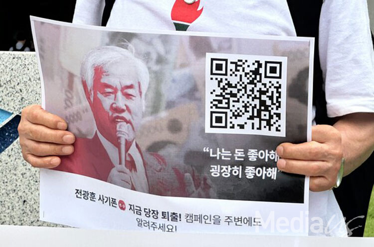 16일 언론중재위원회가 위치한 한국프레스센터 앞에서 열린 '전광훈의 언론사 입막음용 조정신청 규탄·사기폰 제재촉구' 기자회견에서 한 참석자가 피켓을 들고 있다.  (사진-미디어스)