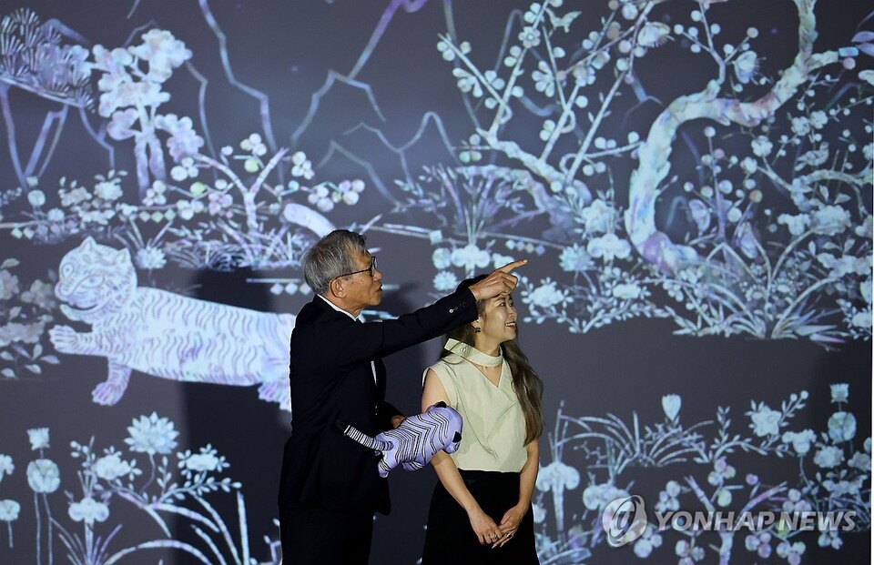 8월 21일 서울 용산구 국립중앙박물관을 예방한 넷플릭스 애니메이션 '케이팝 데몬 헌터스'의 매기 강 감독이 유홍준 관장과 함께 디지털 실감영상관에서 영상을 감상하고 있다. (서울=연합뉴스)