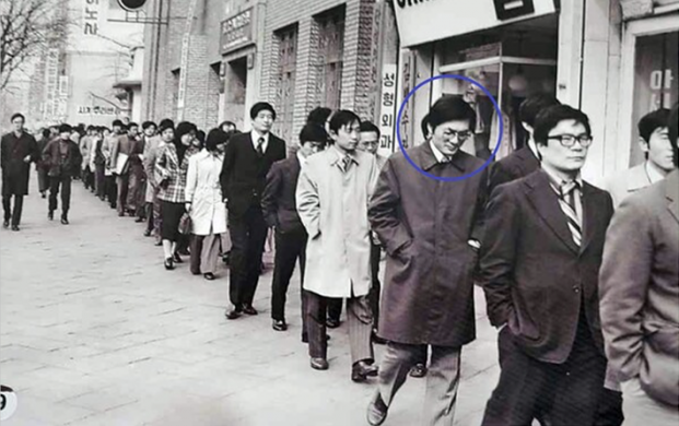 1975년 동아투위 위원들이 출근 시간에 동아일보 사옥 앞에서 침묵 시위를 벌이고 있다. 파란색 원이 안종필 기자다. (사진=자유언론실천재단 제공)