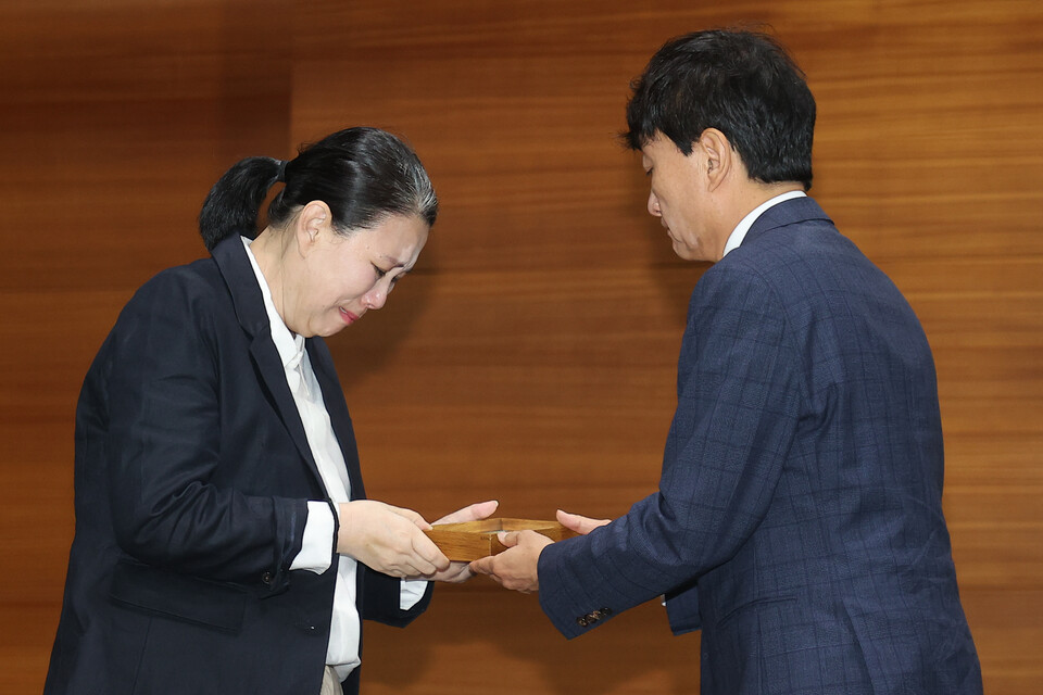 직장 내 괴롭힘을 호소하며 숨진 MBC 기상캐스터 오요안나 씨 어머니 장연미 씨가 15일 서울 마포구 상암동 MBC 사옥에서 고인의 명예사원증을 받은 뒤 눈물을 흘리고 있다. (연합뉴스)