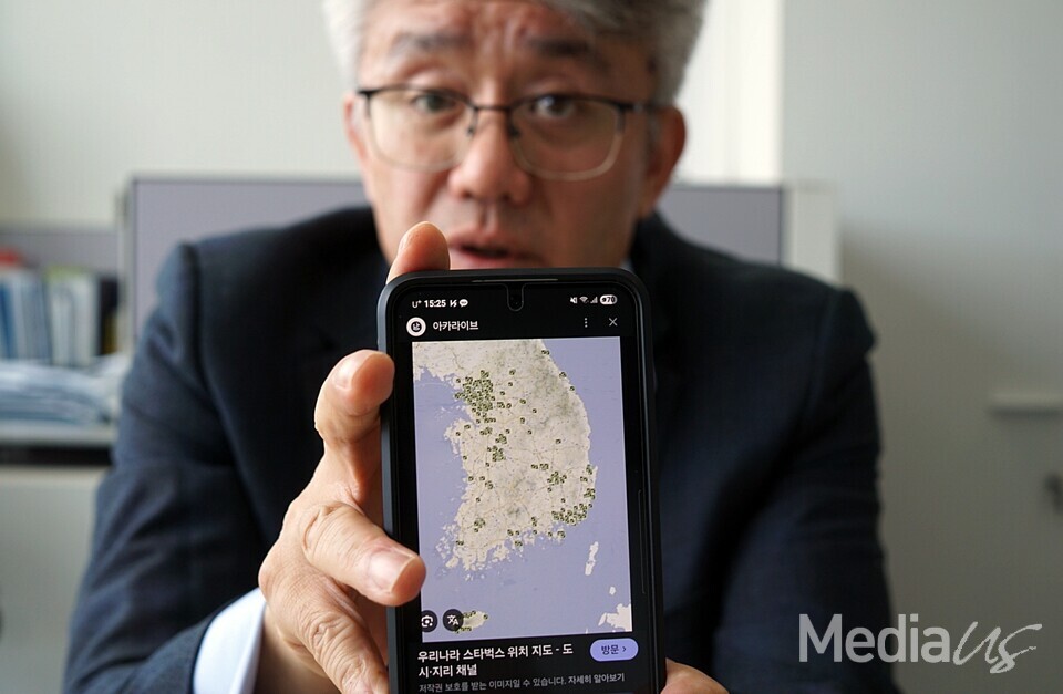 김경태 MBC 공영미디어연구소장이 국내 스타벅스 위치를 표시한 지도를 펼쳐 보이고 있다 (사진=미디어스)