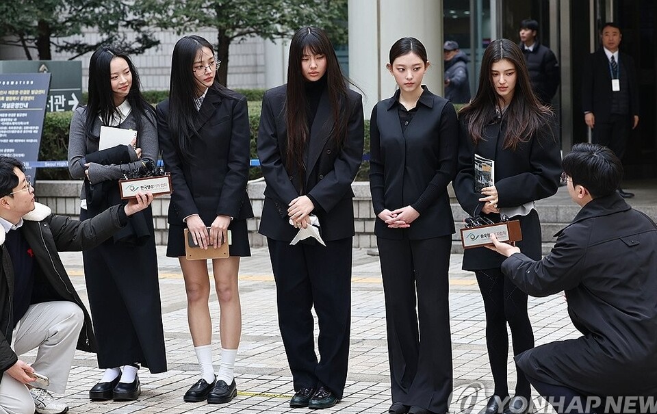 걸그룹 뉴진스가 지난 3얼 7일 서울 서초구 서울중앙지방법원에서 열린 '기획사 지위보전 및 광고계약 체결 등 금지' 가처분 신청의 심문기일을 마친 뒤 법원 청사를 나서며 취재진 질문에 답하는 모습.  왼쪽부터 하니, 민지, 혜인, 해린, 다니엘 (사진=연합뉴스)